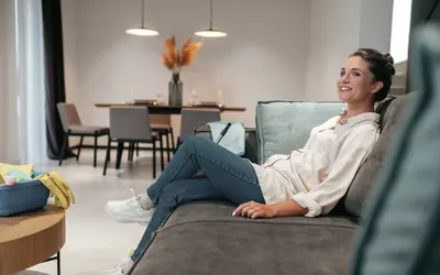 Inquilina relajada en el sofá de su piso de alquiler