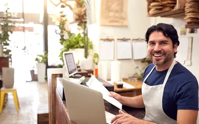Shop owner working on a laptop at the counter