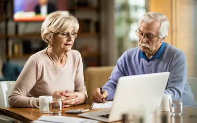 Senior couple reviewing their finances on a laptop