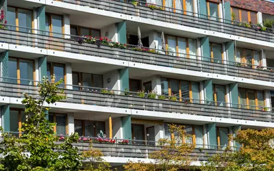 Fachada de edificio residencial con balcones y plantas