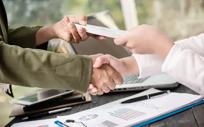 Apretón de manos sobre documentos e informes de empresa