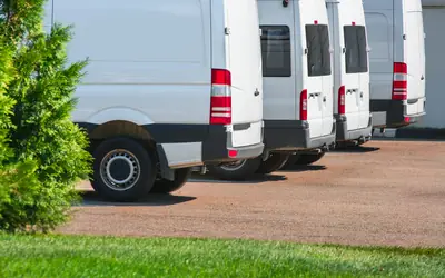 Row of white company vans parked