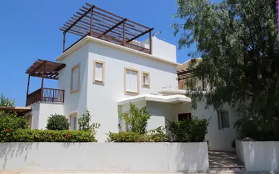 Casa blanca mediterránea con jardín en un día soleado