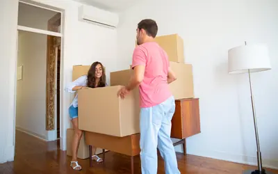 Young couple carrying moving boxes into their new flat