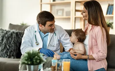 Family doctor examining a baby with its mother
