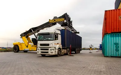Truck being loaded with a container at a port terminal